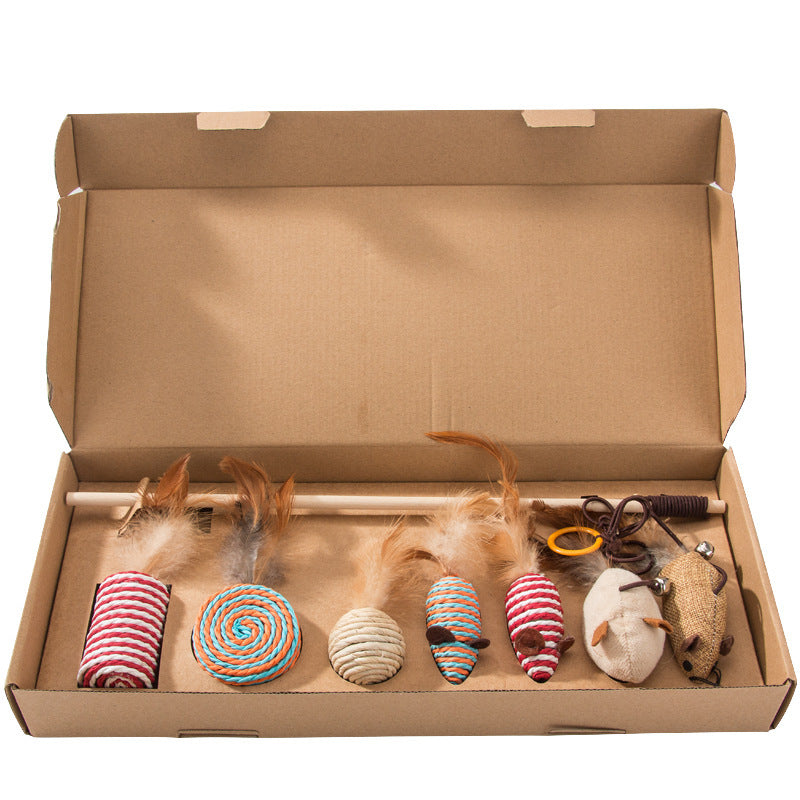 Assorted cat toys with feathers, yarn, and mice in a cardboard box for pet playtime fun.