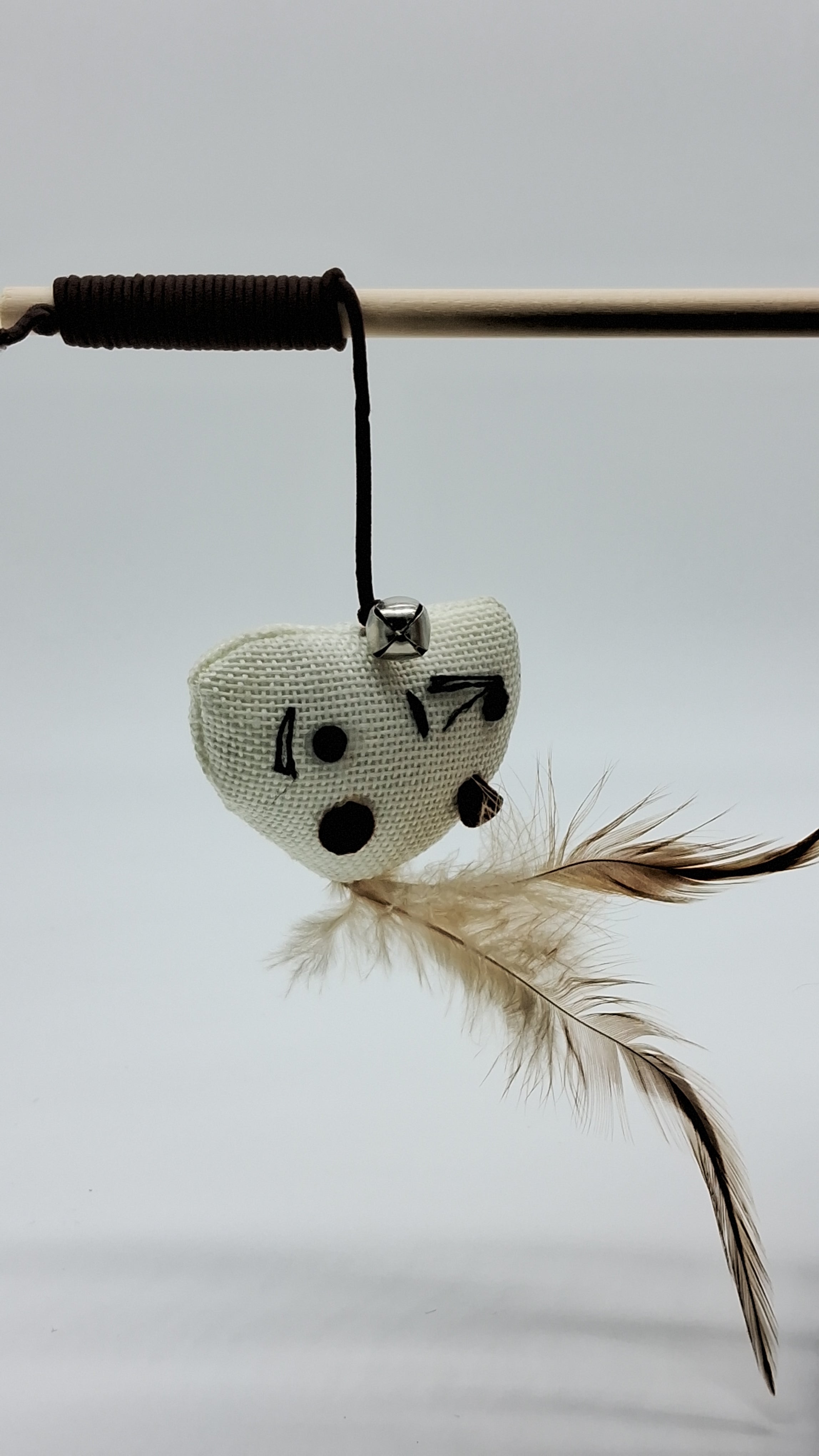 Cat wand toy with heart-shaped mouse, feathers, and bell for interactive play