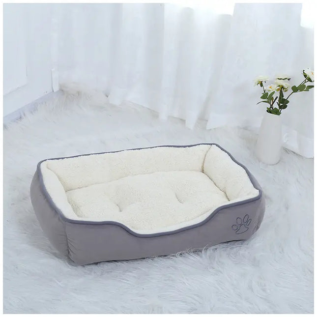 Grey Oxford Cloth Plush Pet Bed with white faux fur lining on a white fluffy rug