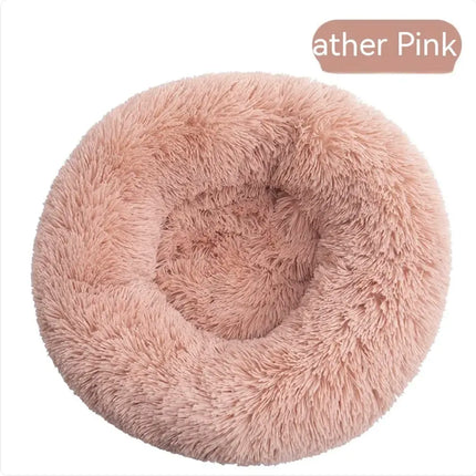 Plush round washable pet bed in soft pastel pink for cats and dogs.