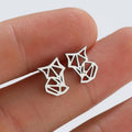 Geometric cat-shaped stud earrings held on fingertips, silver tone, minimalist pet-themed jewelry