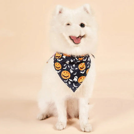 White dog wearing a Halloween themed bandana with pumpkin and ghost patterns