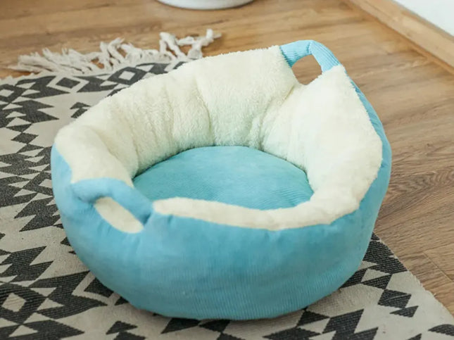 Plush light blue pet nest bed with soft white fleece lining on a patterned rug