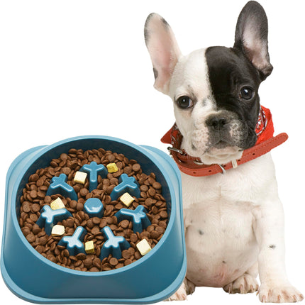 French Bulldog sitting next to a blue slow feeder dog bowl filled with dry kibble.